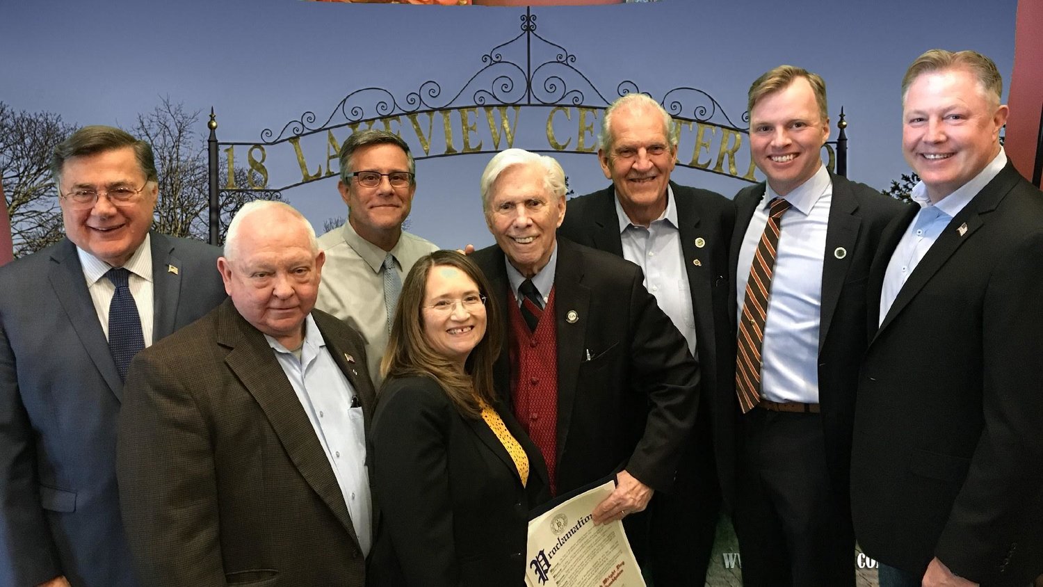From left to right: Supervisor Ed Romaine, Legis. Dominick Thorne, Ralph Wright, trustee Tom Ferb, trustee Patrick McHeffey, councilman Neil Foley. Front row:  Bill Doyle, representing Sen. Alexis Weik; Marian H. Russo, chair of Friends of Lakeview Cemetery.